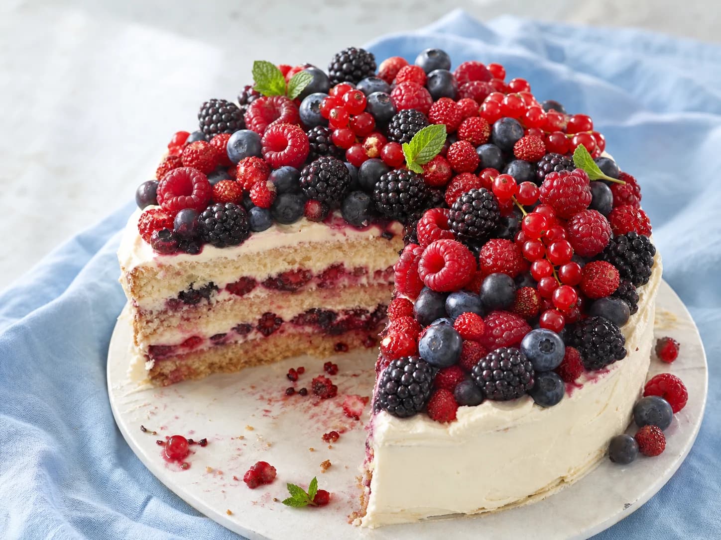 Eine Vanillecremetorte mit Brombeeren, Johannisbeeren, Heidelbeeren und Himbeeren